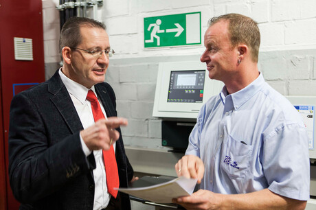 Kaeser Kompressoren 工程师 Hages 和 ZF Friedrichshafen 员工 Baumgarten 正在讨论压缩空气站计划